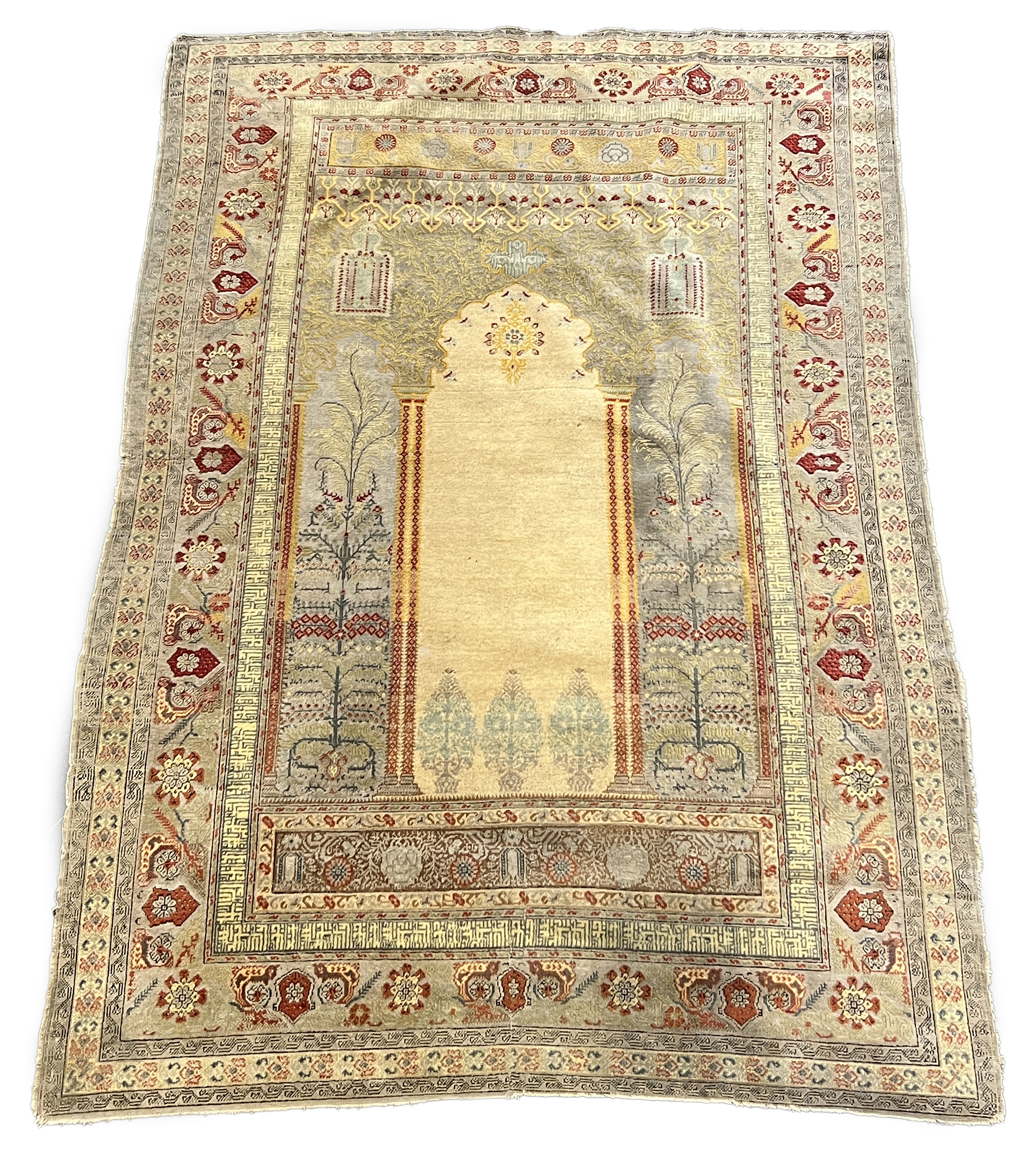 A Turkish silk prayer rug, with central mihrab and stylised floral borders, 205 x 122cm. Condition - worn and faded throughout, all edges worn with a degree of losses.